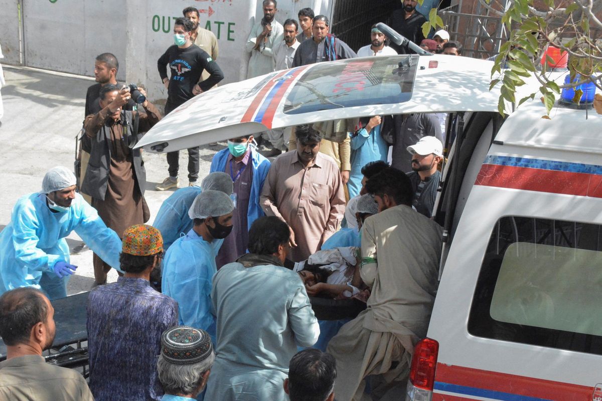 Men and paramedic staff help transport a man who was injured in a blast in Mastung to a hospital in Quetta, Pakistan.
