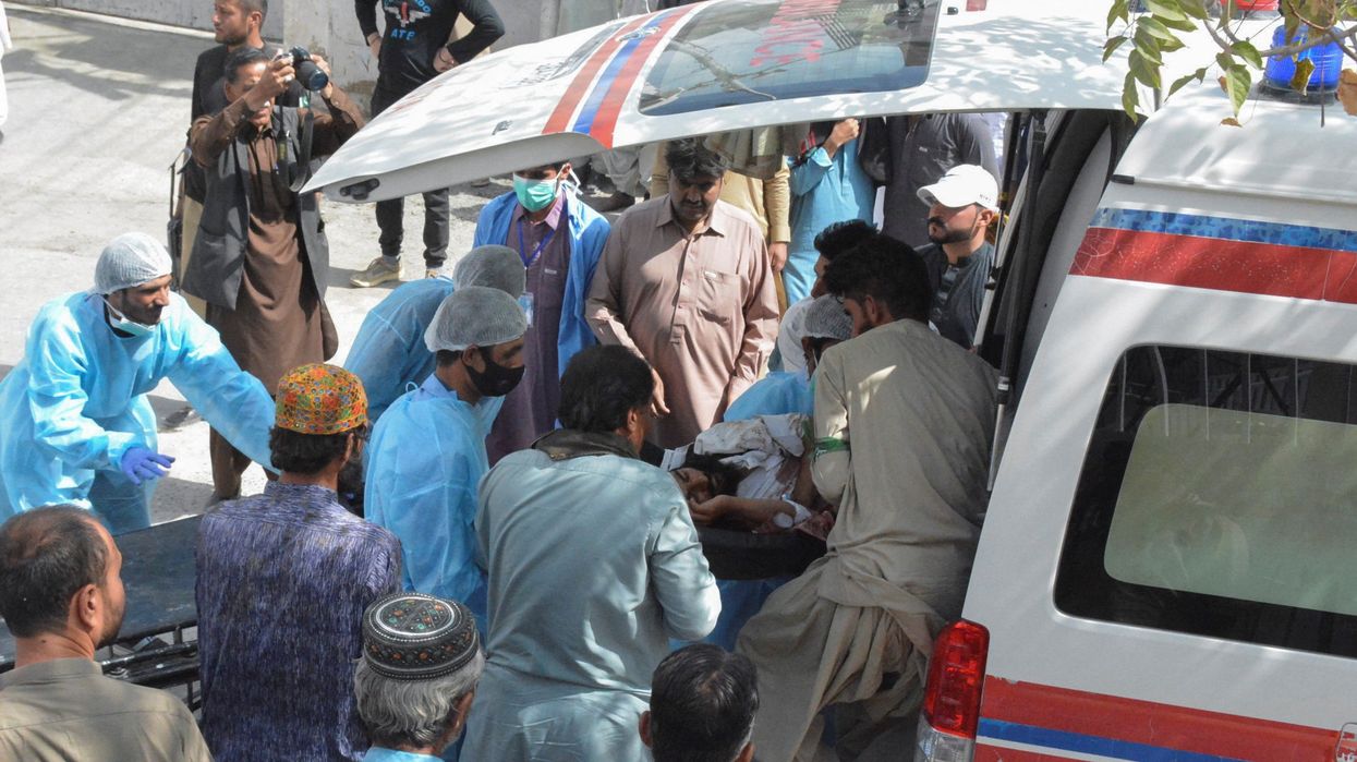 Men and paramedic staff help transport a man who was injured in a blast in Mastung to a hospital in Quetta, Pakistan.
