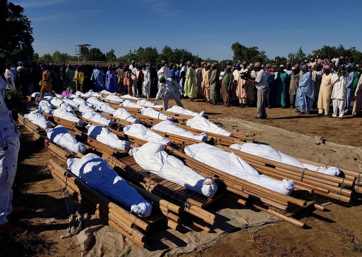 Men gather near dead bodies of people who were killed by militant attack, during a mass burial at Zabarmari, in the Jere local government area of Borno State, in northeast Nigeria, November 29, 2020