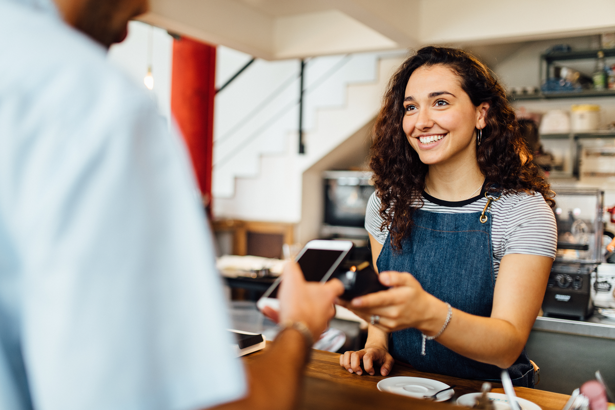 Merchant smiling as she engages with a customer