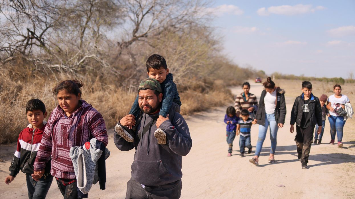 Migrant families with children walk along a dirt road after crossing the Rio Grande River into the United States from Mexico in Penitas, Texas, U.S., March 6, 2021.