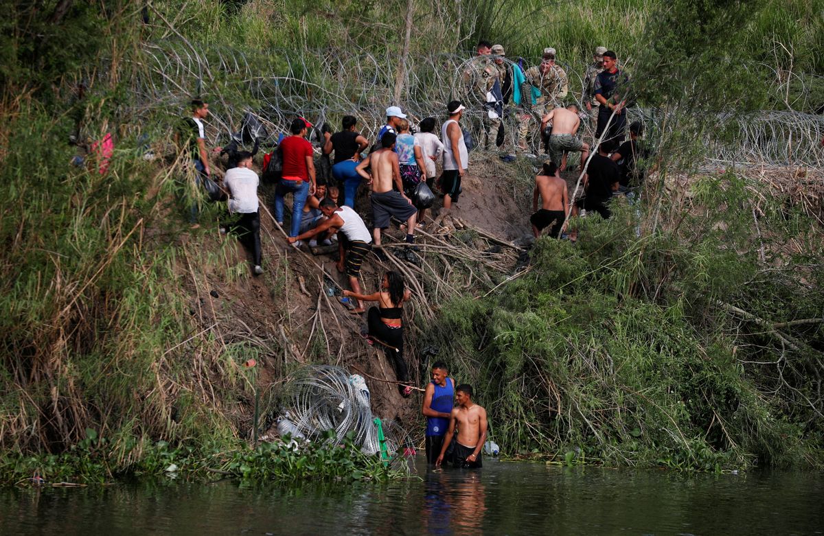 Migrants cross the Rio Bravo river to turn themselves in to U.S. Border Patrol agents in Matamoros, Mexico.