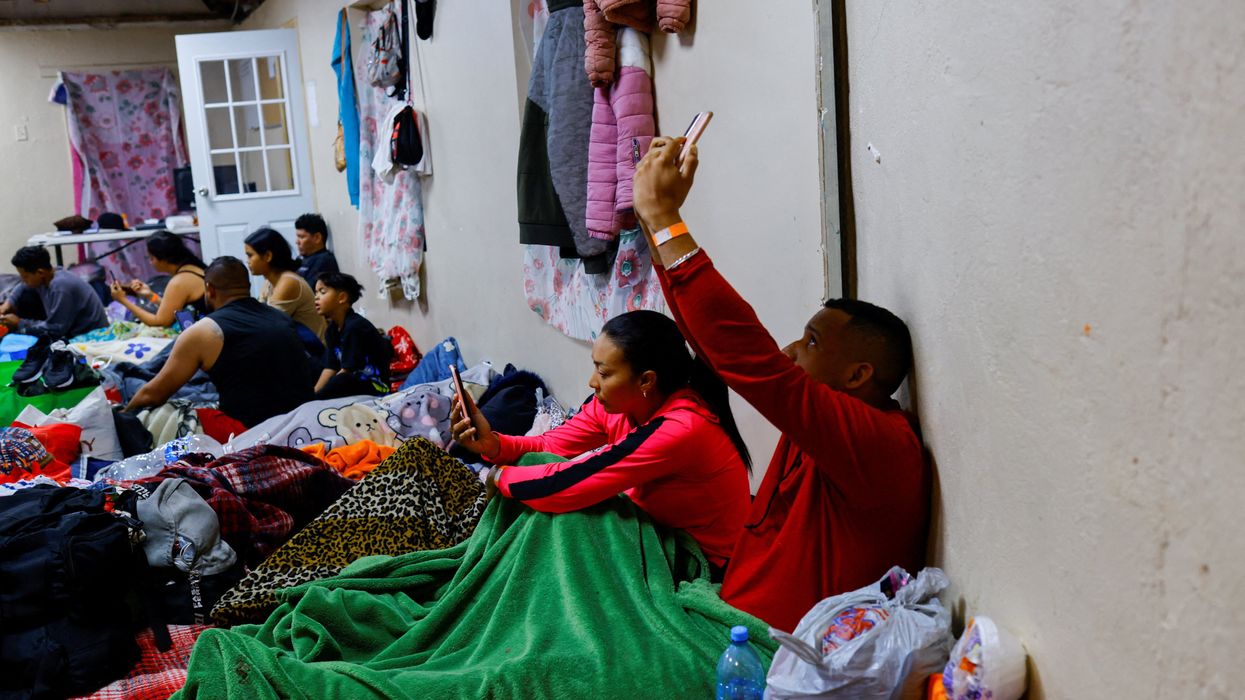Migrants use their phones to access the U.S. Customs and Border Protection (CBP) in a shelter near the US-Mexico border in Ciudad Juarez, Mexico February 24, 2023.