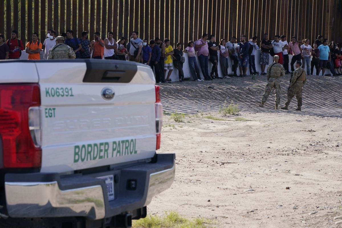 Migrants wait to be transported by border patrol to a detention center in Eagle Pass Texas, USA.