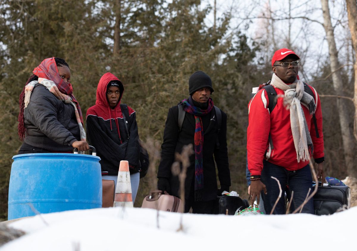 Migrants wait to cross into Canada at Roxham Road, an unofficial crossing point from New York state to Quebec for asylum-seekers.
