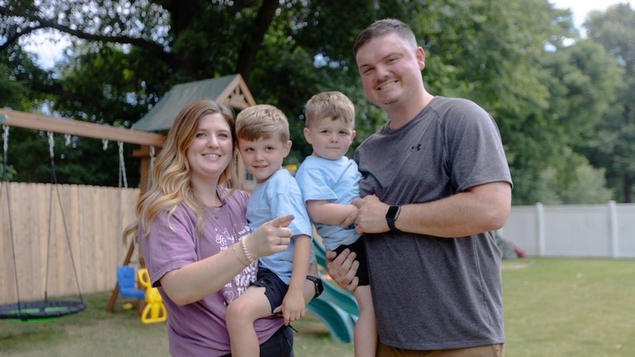 Mother and father carrying their two sons