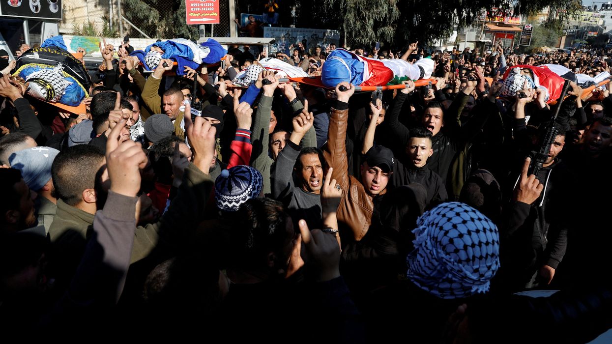 Mourners carry the bodies of Palestinians, including militants, killed in an Israeli raid, during their funeral in Jenin