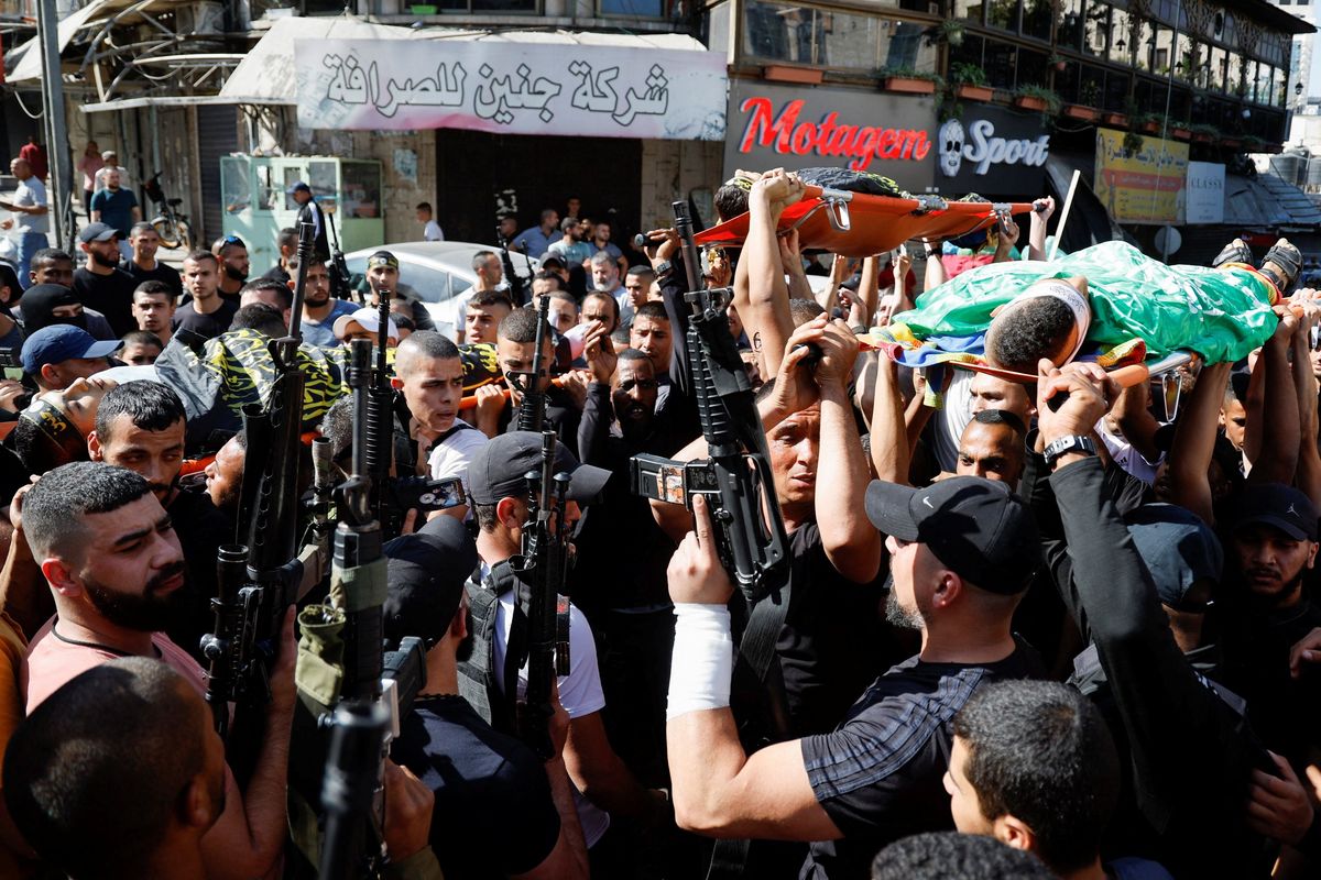 Mourners carry the bodies of three Palestinians who were killed in an Israeli drone strike, during their funeral at Jenin refugee camp in the Israeli-occupied West Bank October 25, 2023.