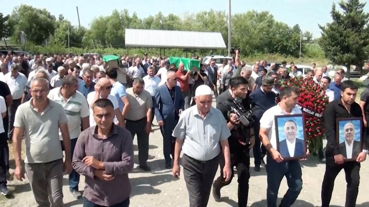 Mourners follow the coffins of Azerbaijani brothers Huseyn and Ziyaddin Safarov, who died in Russian police custody, to a cemetery in Hacibedelli, Azerbaijan, on July 1, 2025.