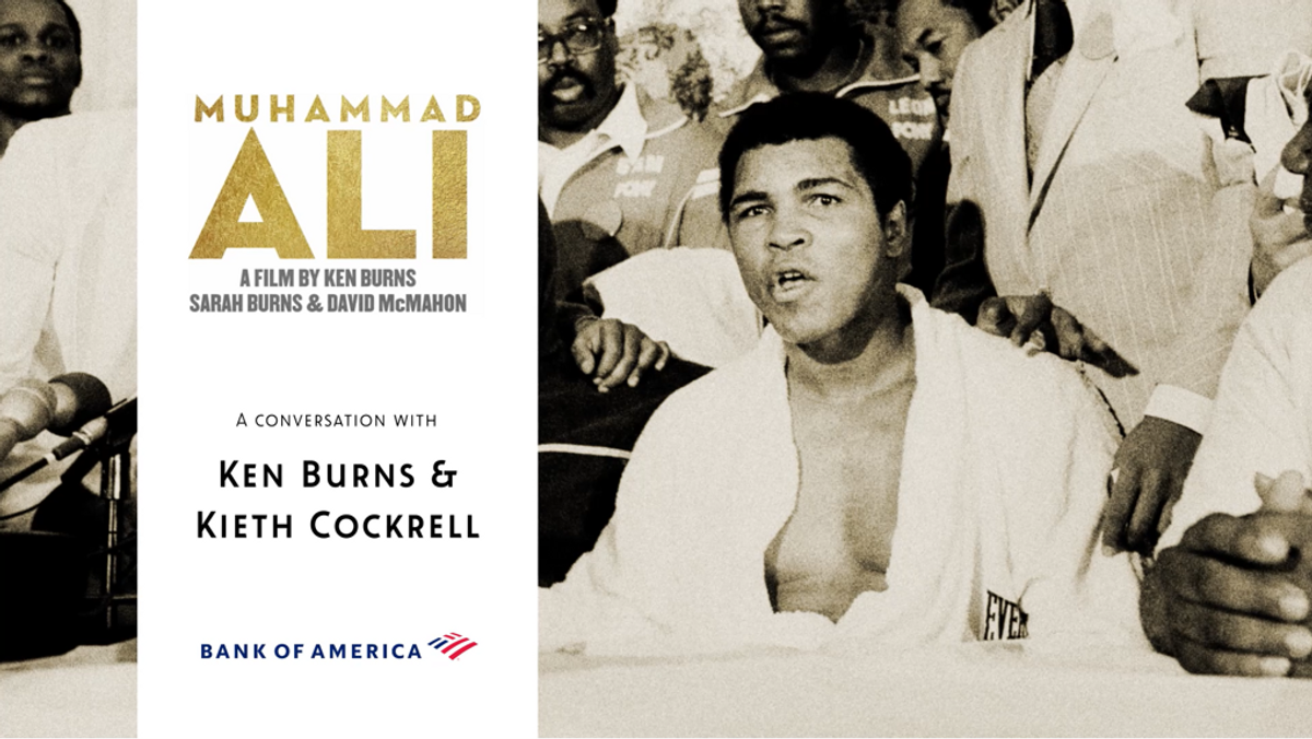 Muhammad Ali wearing a boxing robe with a team gathered behind him