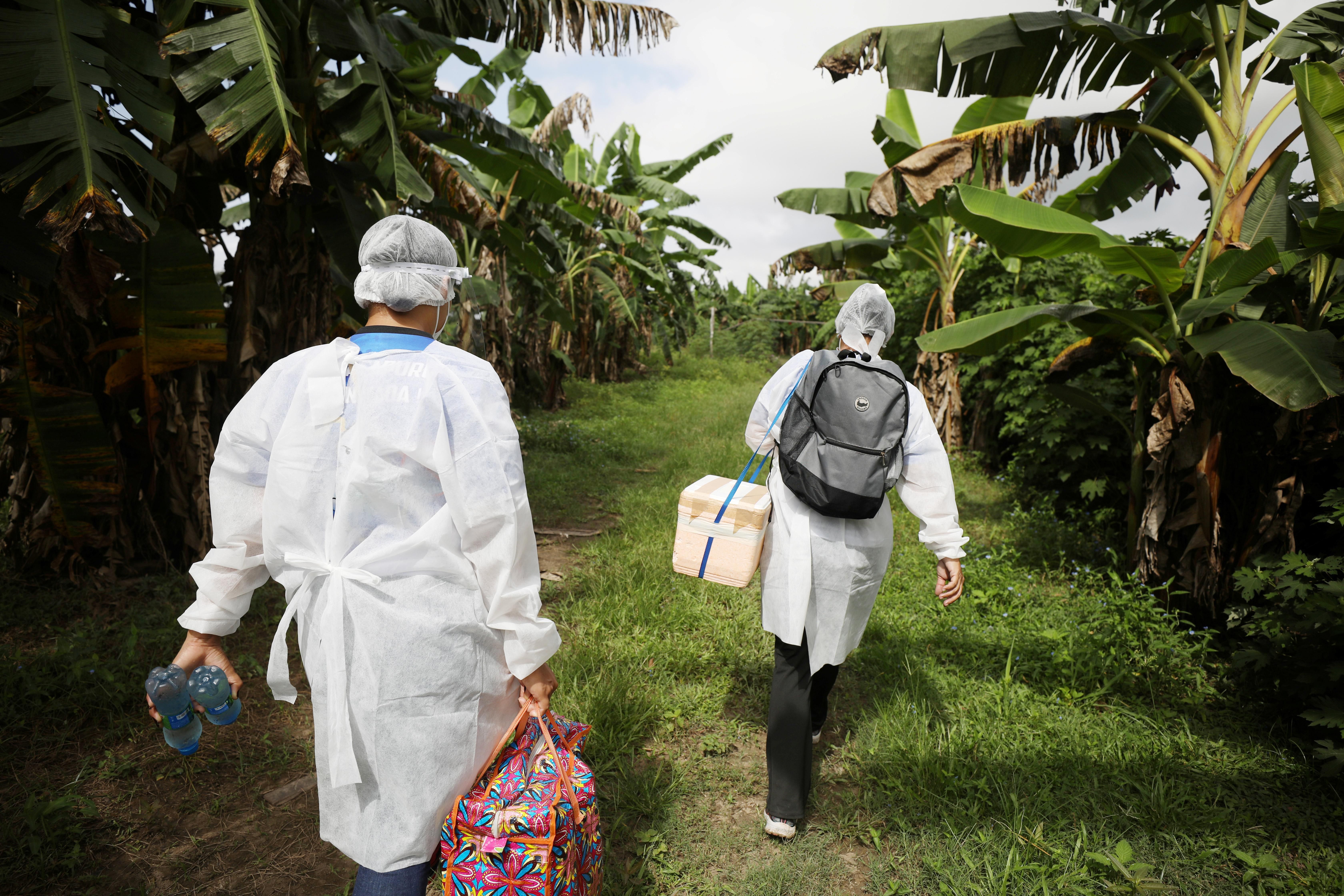 Municipal health workers walk along the Solimoes river banks, where Ribeirinhos (river dwellers) live, before applying the AstraZeneca/Oxford vaccine for the coronavirus disease (COVID-19) to the residents, in Manacapuru, Amazonas state, Brazil, February 1, 2021.