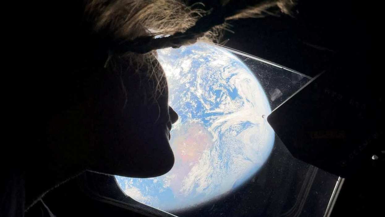 NASA astronaut and Artemis II mission specialist Christina Koch peers out of one of the Orion spacecraft's main cabin windows, looking back at Earth, on April 2, 2026.