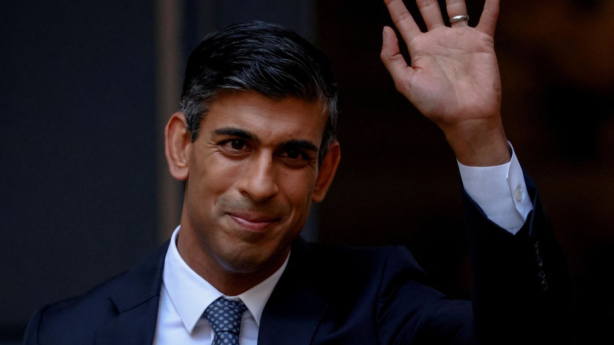 New British Conservative Party leader Rishi Sunak waves outside Tory HQ in London.