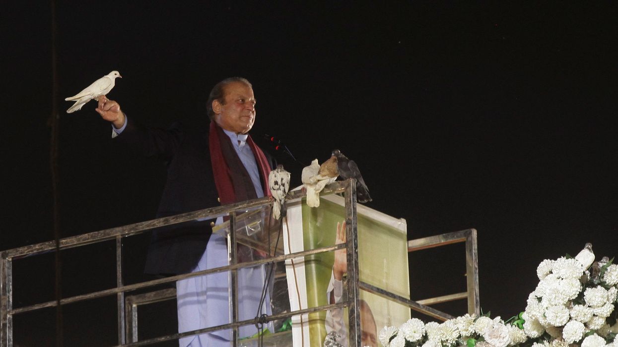 Pakistan's former Prime Minister Nawaz Sharif prepares to release a pigeon in front of supporters in Lahore after returning from self-imposed exile on Oct. 21, 2023.