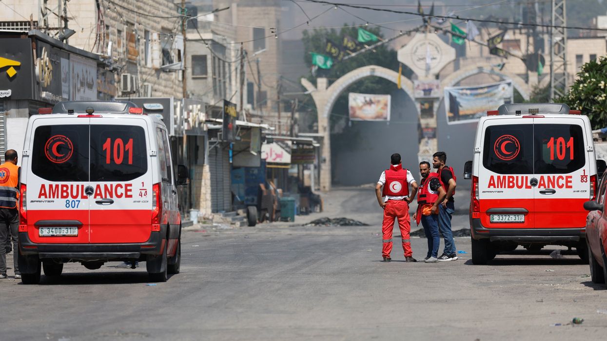 Palestinian medics stand by as smoke rises during an Israeli military operation in Jenin.