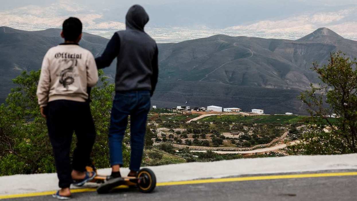 Palestinian youth look at a new Israeli settlement from the Palestinian village of Duma, near Nablus, in the Israeli-occupied West Bank.