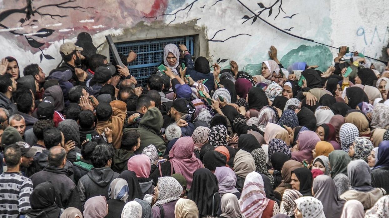 Palestinians gather to receive aid outside an UNRWA warehouse earlier this month in Gaza.