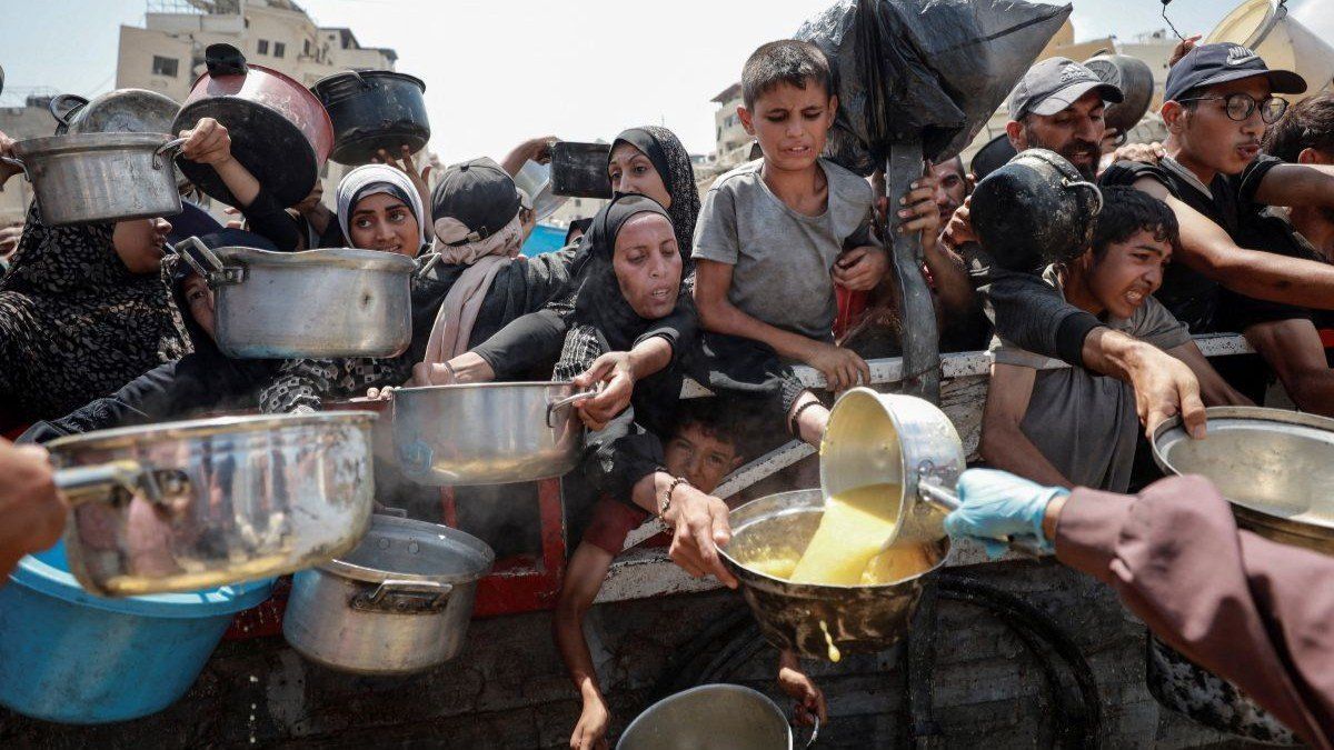 ​Palestinians gather to receive food from a charity kitchen, amid a hunger crisis, in Gaza City, July 28, 2025. 