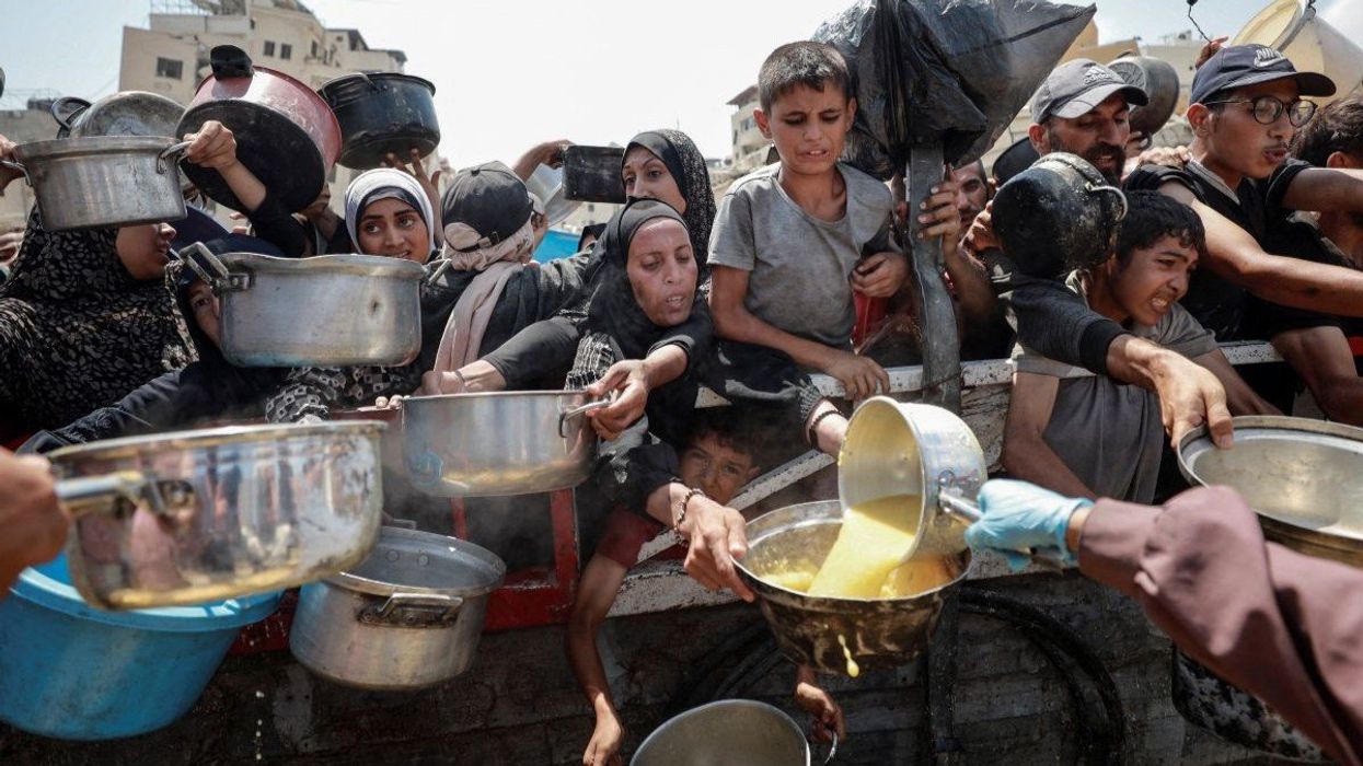 Palestinians gather to receive food from a charity kitchen, amid a hunger crisis, in Gaza City, July 28, 2025.