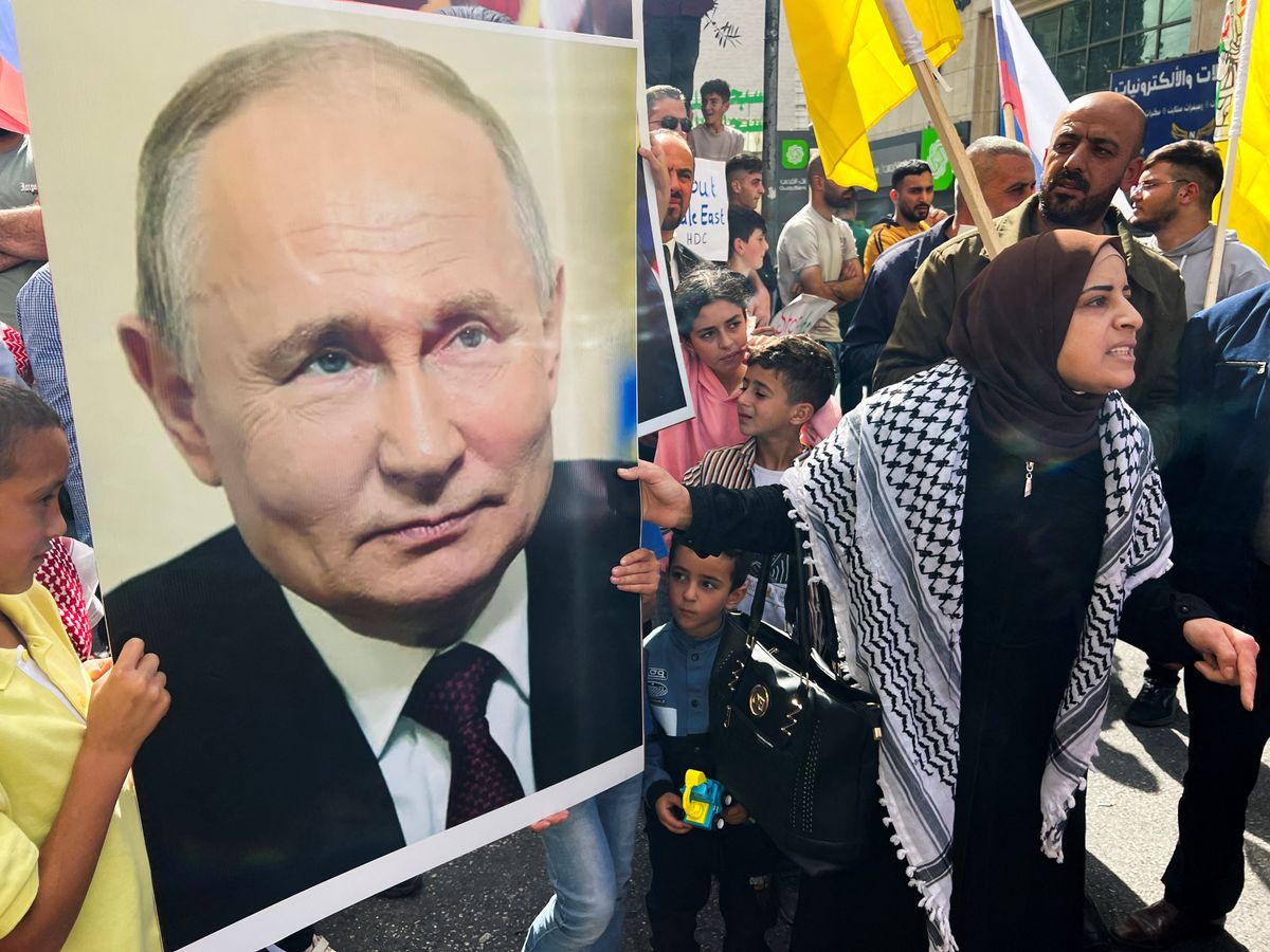 ​Palestinians hold a picture of Russian President Vladimir Putin during a protest in support of the people of Gaza, in the Israeli-occupied West Bank, on Oct. 20, 2023. 
