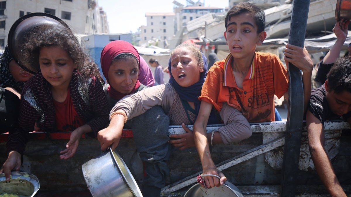 ​Palestinians wait to receive food from a charity kitchen in Gaza City, on August 27, 2025.
