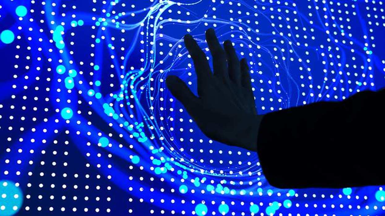 Palm touching a screen with dots on a blue background imitating AI