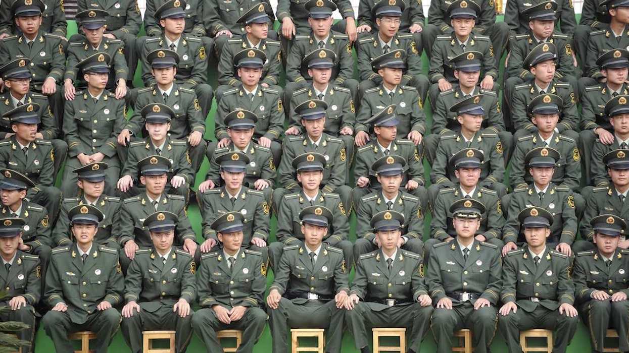 Paramilitary police cadets sit in rows as they watch a parade performance to mark the 20th anniversary of the founding of their military school in Kunming, Yunnan province July 8, 2011.