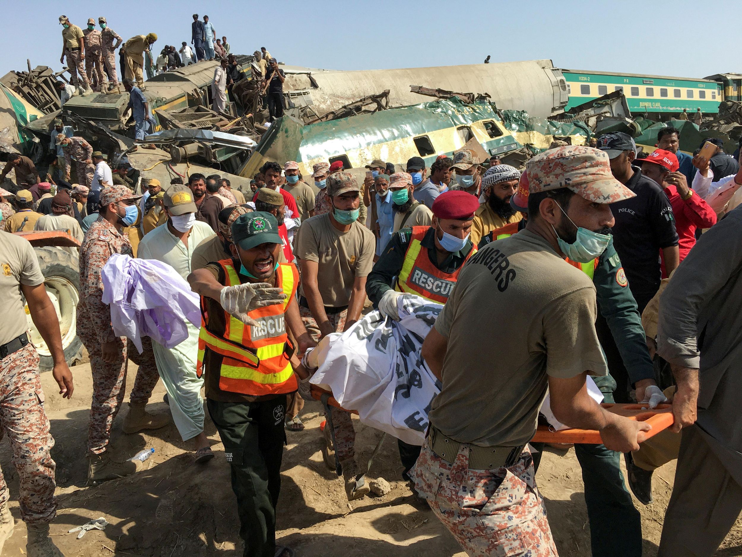 Paramilitary soldiers and rescue workers move a body of a man from the site following a collision between two trains in Ghotki, Pakistan June 7, 2021.