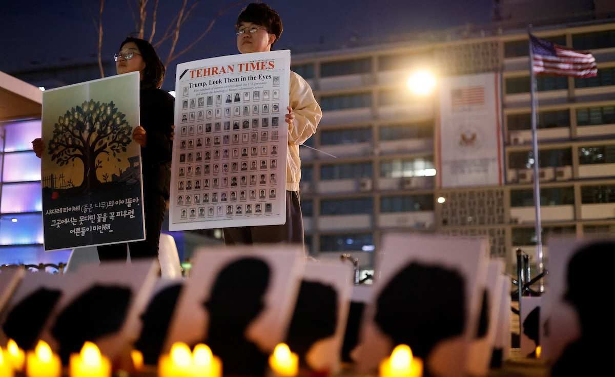 ​Participants hold placards during a protest to condemn the U.S. and Israeli attacks on Iran and commemorate students killed in a strike on a girls' primary school in Minab in southern Iran on February 28, in front of the U.S. embassy in Seoul, South Korea, March 12, 2026. 
