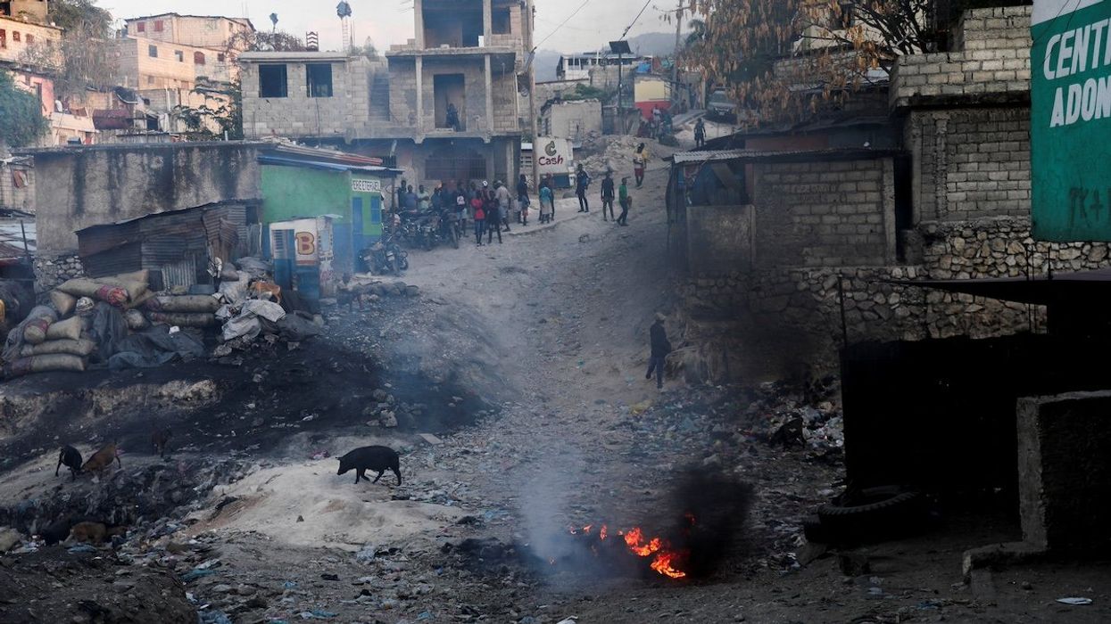 People gather as they watch from afar after an alleged gang member was killed and set on fire, amid an escalation in gang violence, in Port-au-Prince, Haiti March 20, 2024.
