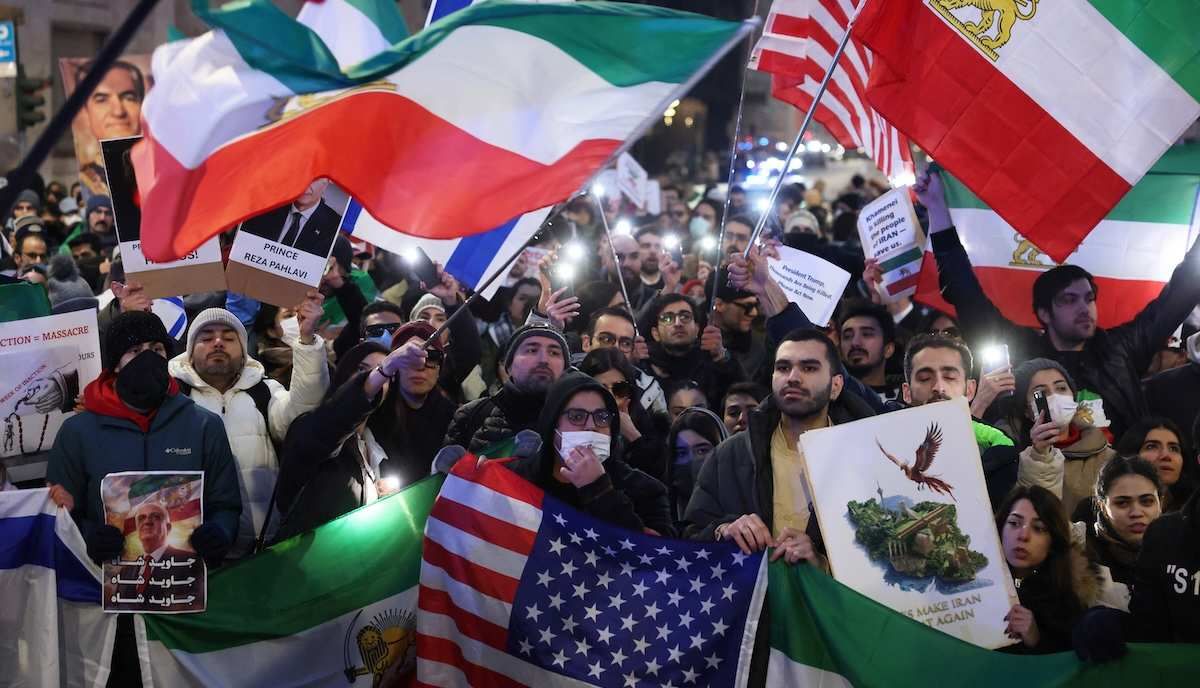 ​People hold flafs and light up their phones outside the U.S. consulate during a rally in support of nationwide protests in Iran, in Milan, Italy, January 13, 2026. 