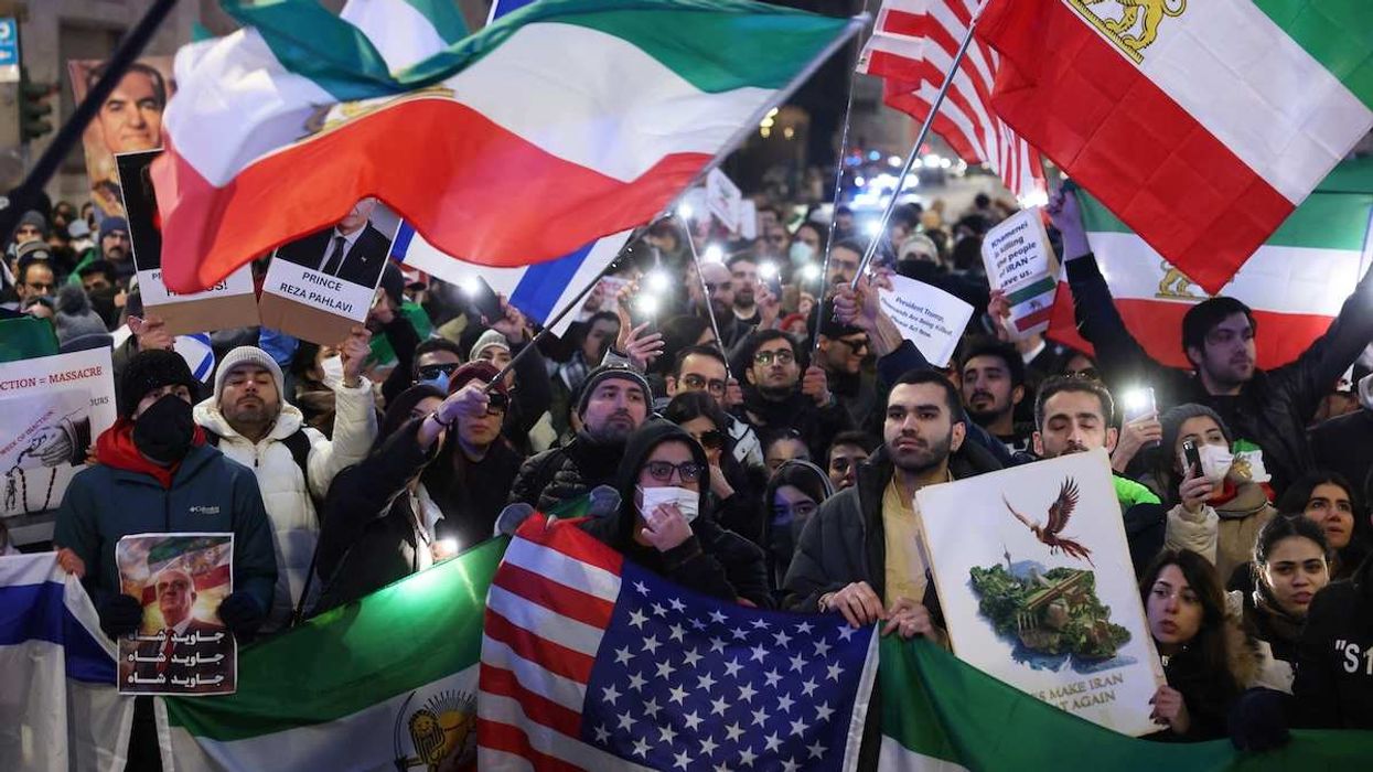 People hold flafs and light up their phones outside the U.S. consulate during a rally in support of nationwide protests in Iran, in Milan, Italy, January 13, 2026.