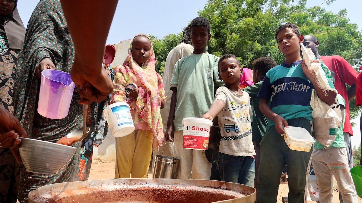 People hold pots as volunteers distribute food in Omdurman, Sudan, September 3, 2023