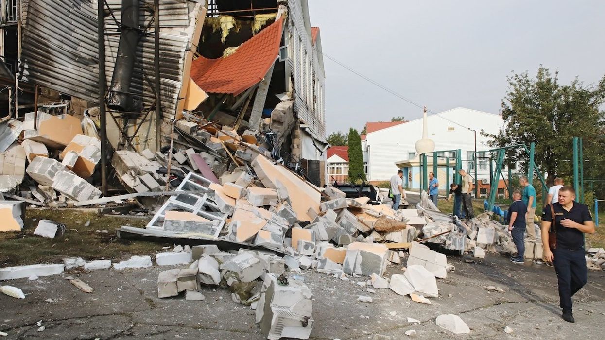People inspect a damaged building after the Russian missile attack on the premises of the lyceum of the Interregional Academy of Personnel Management in Poltava, Ukraine.