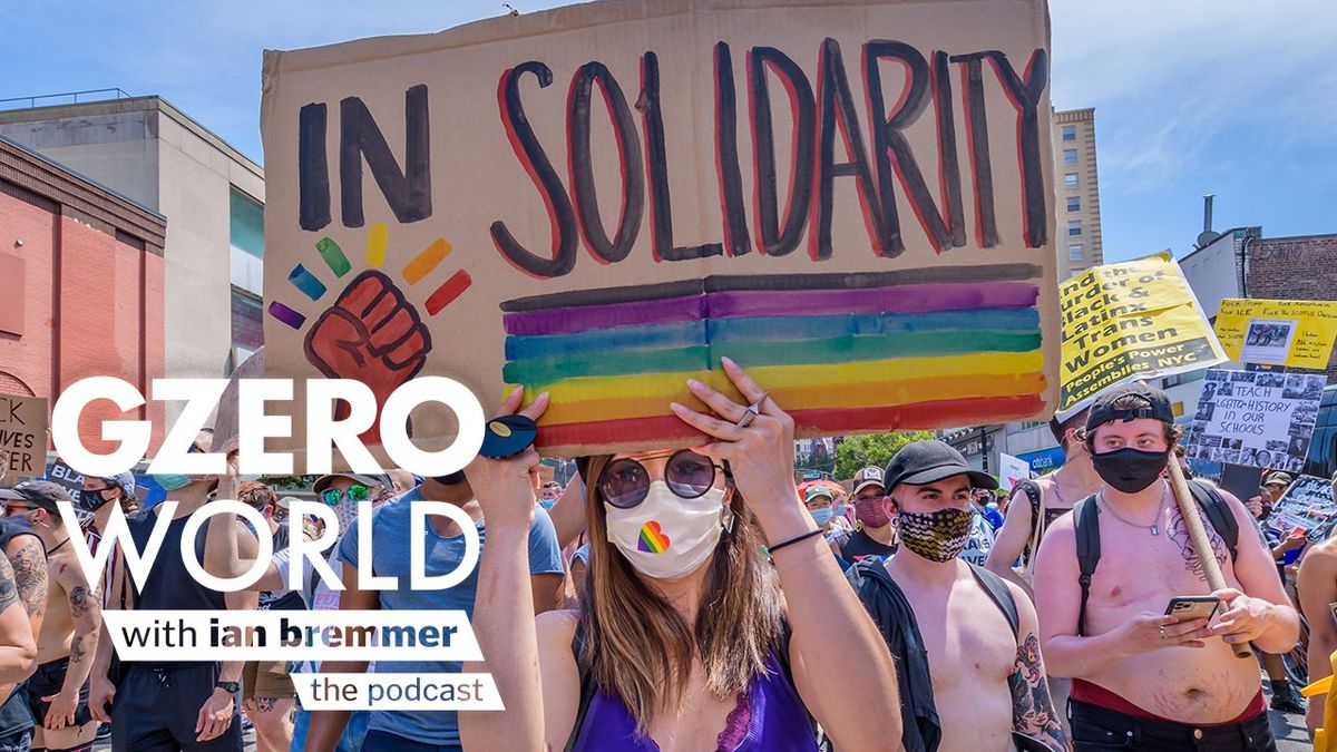 people protesting hoisting colorful placards in the air with the GZERO World with Ian Bremmer - the podcast logo