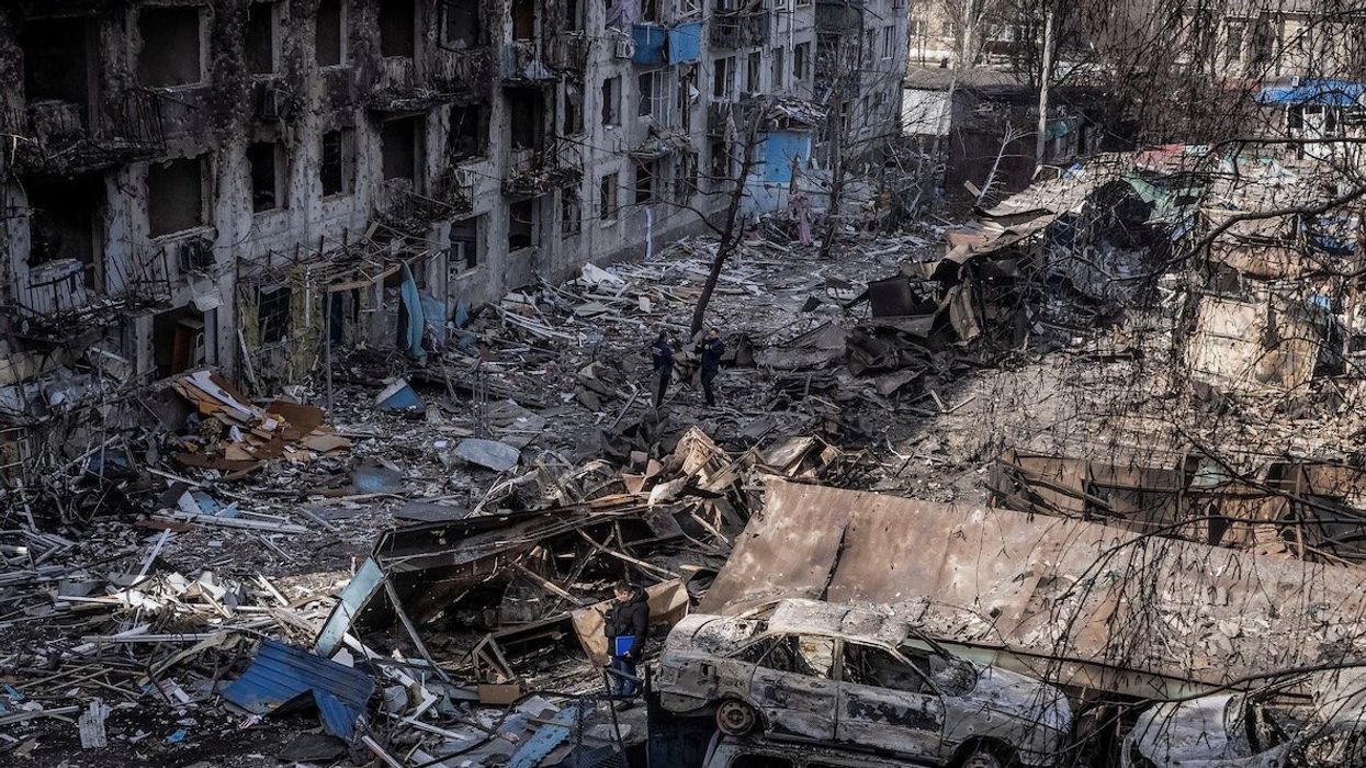 People stand at the site of an apartment building hit by a Russian missile strike, amid Russia's attack on Ukraine, in the town of Dobropillia, Donetsk region, Ukraine, on March 8, 2025.