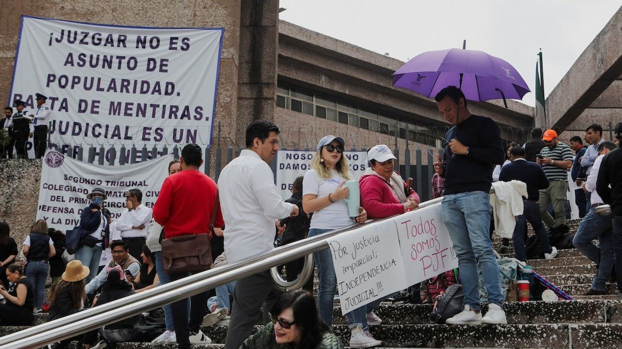 People stand outside the building of the Federal Judiciary Council as Mexico's judicial workers launched an indefinite nationwide strike ahead of votes by lawmakers on overhauling the country's judiciary, including moving to the popular election of judges, in Mexico City, Mexico August 19, 2024.