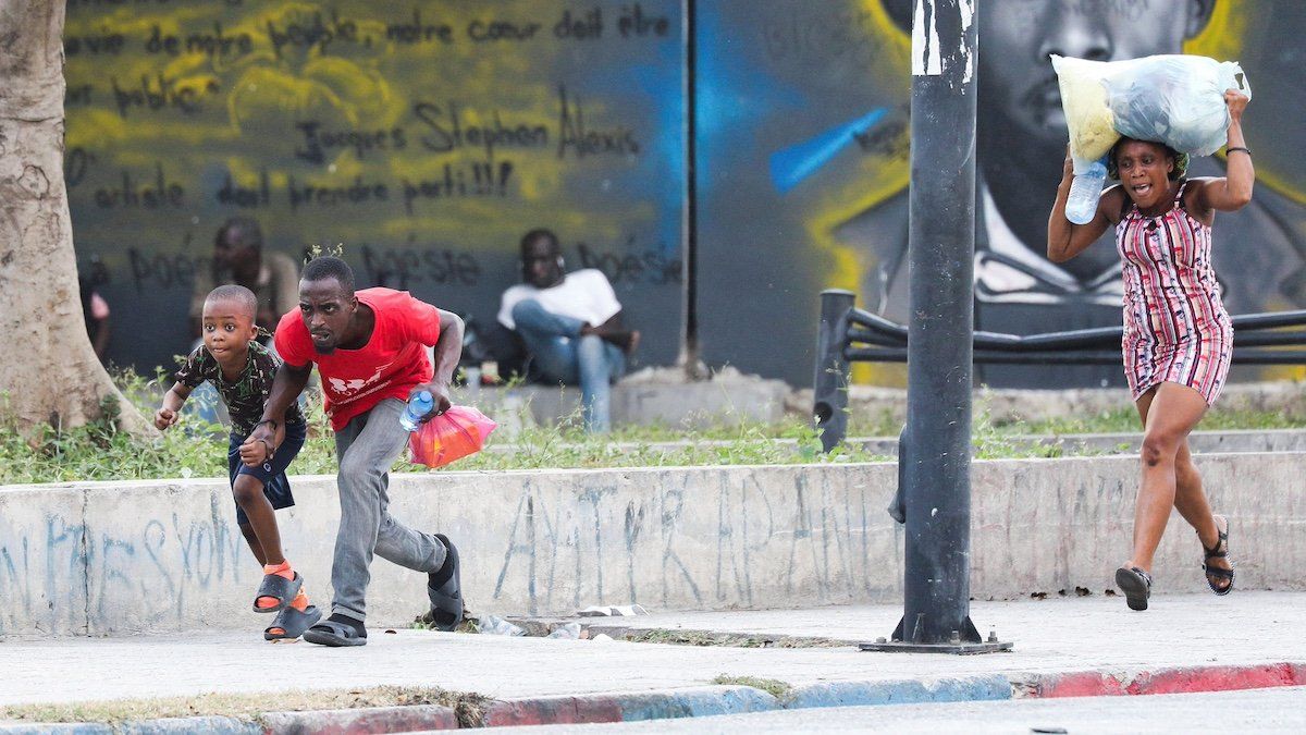 People take cover from gunfire near the National Palace, in Port-au-Prince, Haiti March 21, 2024. 
