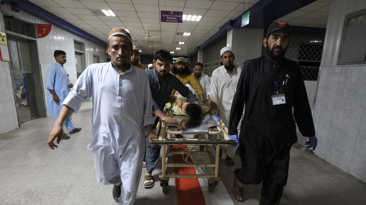 People transport a man injured by a blast in Bajaur, Pakistan, on Sunday.