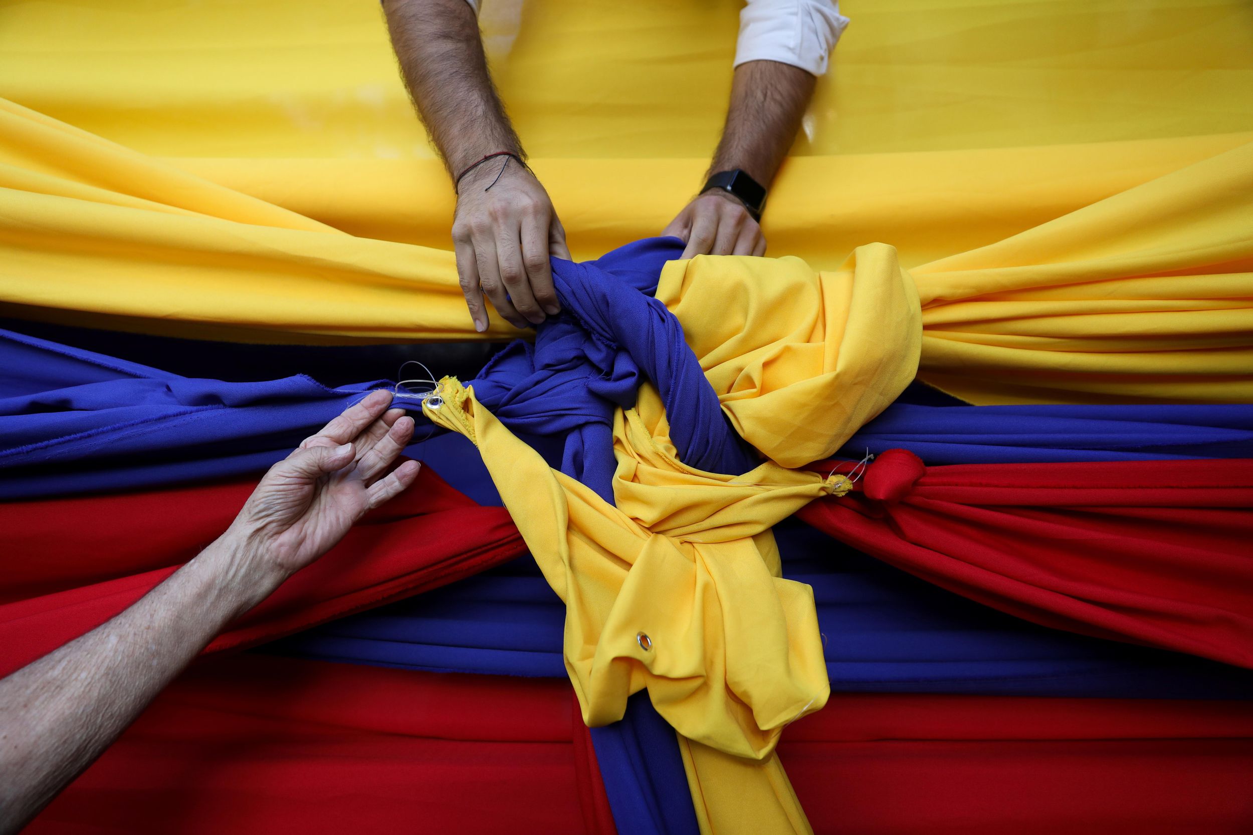 People untie cloth tarps with colors of the Venezuelan flag after a citizen assembly with Juan Guaidó, speaker of the National Assembly, in Caracas. Reuters