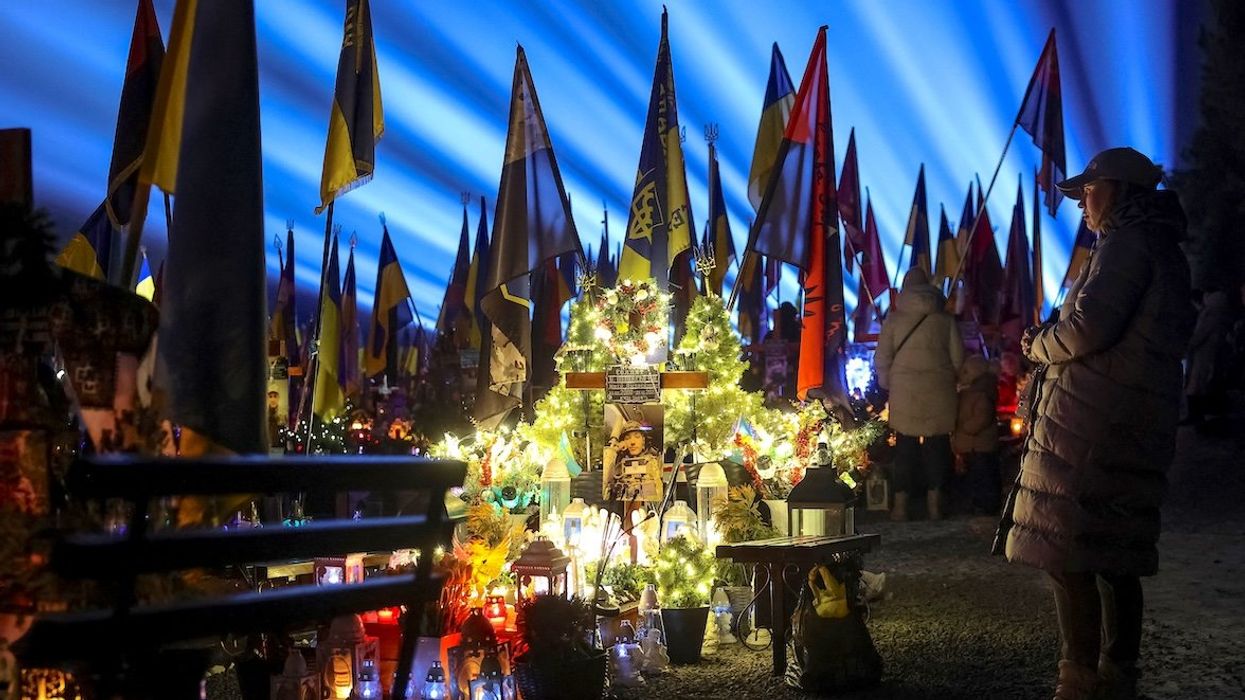 People visit the graves of their relatives killed during Russia's invasion of Ukraine. A large-scale light installation "Lights of Memory" was held to mark the third anniversary of the full-scale Russian invasion at the Lychakiv cemetery in Lviv, Ukraine, on Feb. 23, 2025.