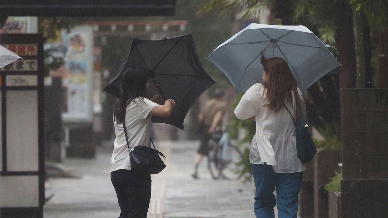 People walk against strong wind in Kagoshima on Aug. 29, 2024, as Typhoon Shanshan made landfall on Japan's southwestern main island of Kyushu.