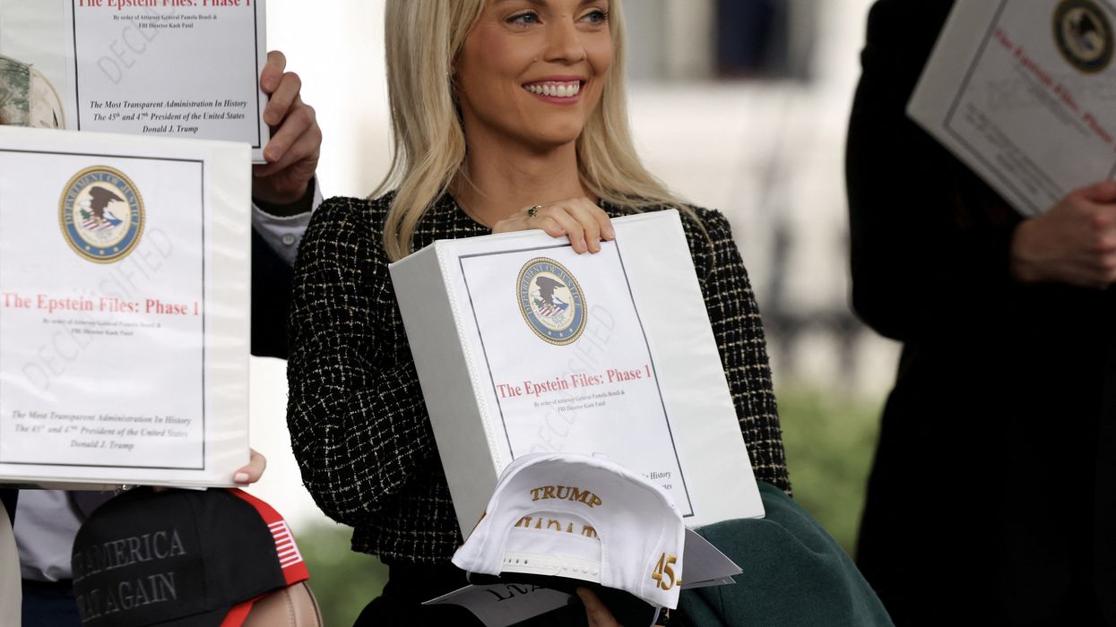 People walk out of the West Wing of the White House with "The Epstein Files: Phase 1" binders, in Washington, D.C., U.S., February 27, 2025.