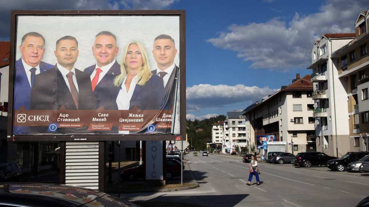 People walk past near a campaign billboard featuring Milorad Dodik, Aco Stanisic, Savo Minic, Zeljka Cvijanovic and Damjan Skipina, candidates of the Alliance of Independent Social Democrats (SNSD) in Bosnia and Herzegovina's 2026 general election, in Pale, Bosnia and Herzegovina.