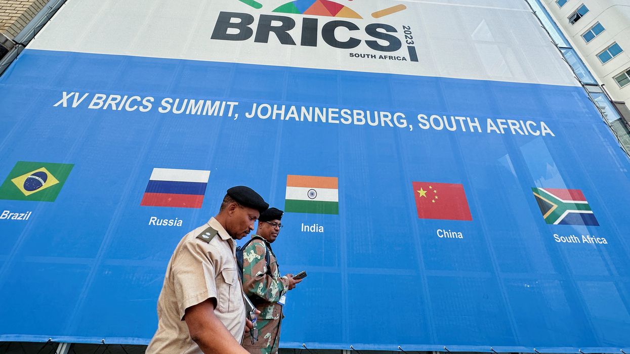 People walk past the Sandton Convention Centre, where the BRICS Summit is being held in Johannesburg, South Africa.