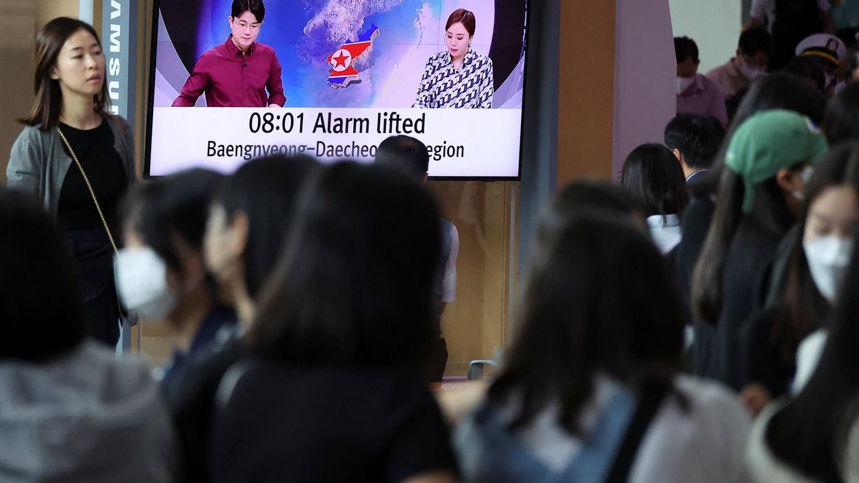 People watch a news report on North Korea firing what it called a space satellite toward the south, in Seoul, South Korea.