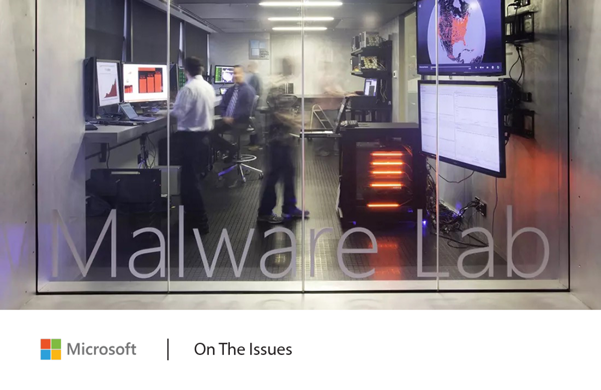 People working at computers in a room labeled Malware Lab