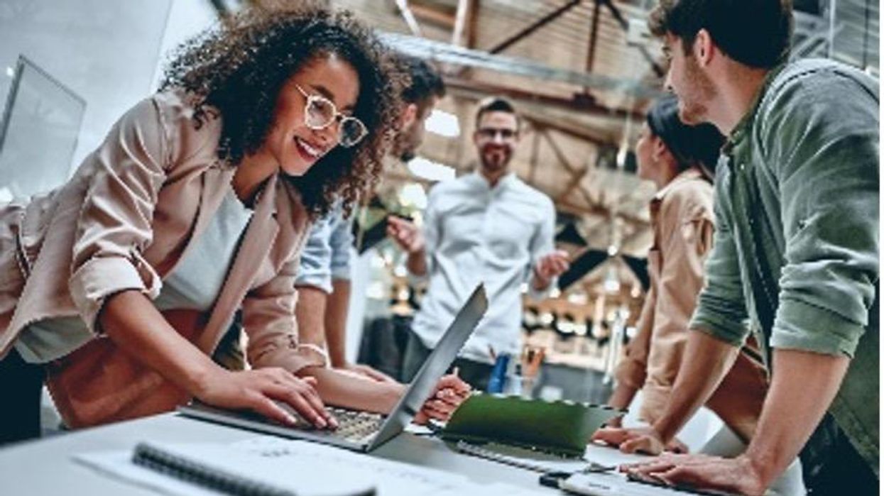 People working with notebooks and their computers opened, smiling.