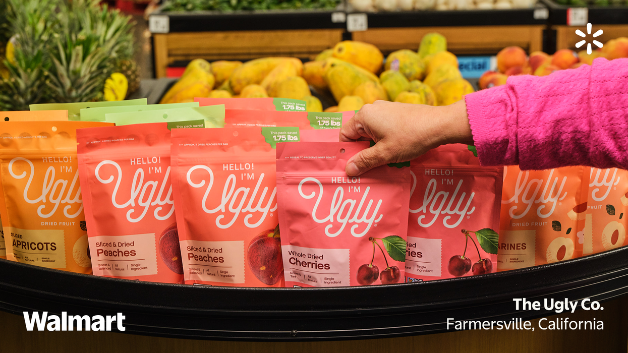 Person picking up packets of Hello I'm Ugly dried fruits at a store
