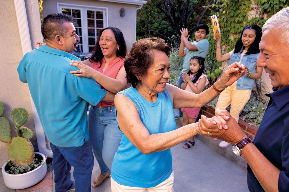Photograph of a group of Hispanic family members dancing in the yard of a private home